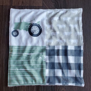 May include: A green and white baby blanket with a tractor, a green and white wood pattern, a white and gray pig pattern, and a black and white checkered pattern.