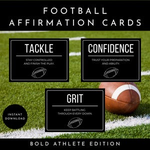 May include: Football affirmation cards featuring three black rectangular cards with white text. The cards display the words TACKLE, CONFIDENCE, and GRIT with motivational phrases and football icons. A brown football sits on a green grass field.