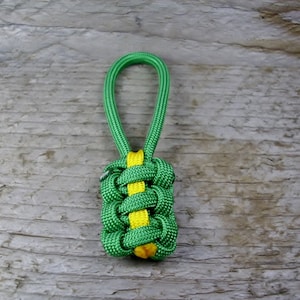 May include: A green and yellow paracord zipper pull with a knot design.