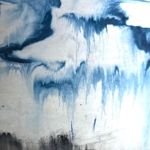 May include: Abstract art piece with a white background and flowing blue and dark blue paint. The paint appears to be dripping down the canvas, creating a unique and textured effect. The artwork has a modern and artistic feel.