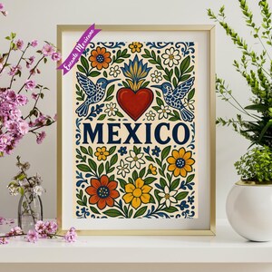 Pode incluir: Uma impress&atilde;o de arte emoldurada com uma moldura dourada. A impress&atilde;o apresenta um cora&ccedil;&atilde;o vermelho central com uma chama, a palavra "MEXICO" em azul marinho e desenhos florais e beija-flores coloridos. A impress&atilde;o tem um fundo creme.