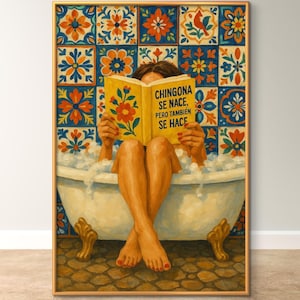 以下が含まれることがあります： フレームに入ったプリントは、本を読んでいる浴槽の中の人を描いています。テキストは「CHINGONA SE NACE、PERO TAMBIEN SE HACE」です。背景にはカラフルなタイルがあります。バスタブには金の爪の足が付いています。