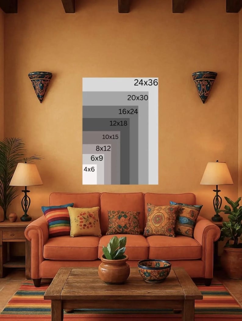 May include: A living room scene with an orange sofa, wooden coffee table, and colorful pillows. A framed print displays various size options, including 24x36 inches. The room is decorated with lamps, wall sconces, and a striped rug, creating a warm, inviting atmosphere.