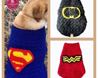 May include: Three crocheted pet sweaters. One is blue with a red and yellow emblem, one is black with a yellow and black bat emblem, and one is red with a yellow and black winged emblem. Each sweater features a textured yarn construction.