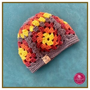 May include: A crocheted beanie hat in brown, orange, red, and yellow. The hat is made with granny squares and has a textured look.
