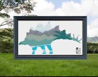 May include: Cross stitch pattern of a Stegosaurus dinosaur with a mountain range design. The dinosaur is outlined in blue, green, and gray. The pattern is available as a PDF download.