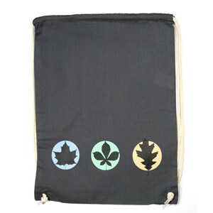 Puede incluir: Una bolsa de cordón gris con tres círculos que presentan siluetas negras de hojas. Los círculos son de color azul, verde y naranja.
