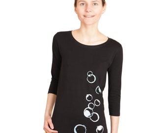 Camiseta feminina preta de manga 3/4 com estampa de bolhas de sabão.