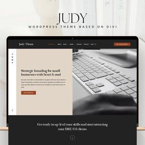 May include: A laptop screen displaying a website design with the name "JUDY" at the top. The website features a neutral color palette with text that reads "Strategic branding for small businesses with heart & soul."