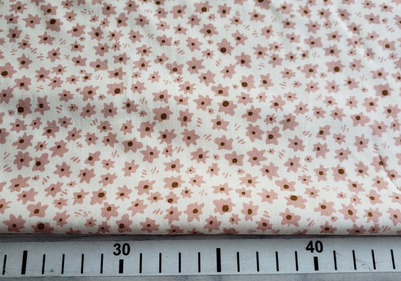 Pu&ograve; includere: Tessuto bianco con un piccolo motivo floreale rosa. Il tessuto &egrave; misurato con un righello che mostra 30 e 40 pollici.