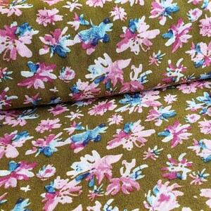 Pu&ograve; includere: Primo piano di un tessuto con sfondo marrone e un motivo floreale rosa e blu.