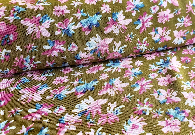 Pu&ograve; includere: Primo piano di un tessuto con sfondo marrone e un motivo floreale rosa e blu.