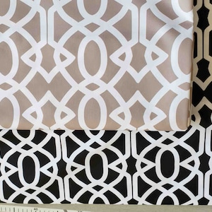 May include: Two fabric swatches featuring a geometric pattern. The top swatch is beige with white geometric shapes. The bottom swatch is black with white geometric shapes.