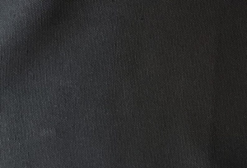 Puede incluir: Primer plano de una tela de lona gris oscuro con textura tejida.