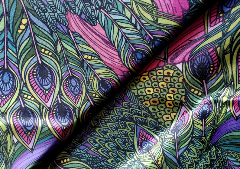 May include: A colorful fabric with a peacock feather pattern. The fabric features a repeating design of green, blue, and pink feathers with intricate details.
