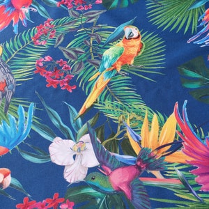 May include: A blue background with a tropical print featuring parrots, toucans, and hummingbirds. The print also includes green leaves, pink flowers, and yellow flowers.