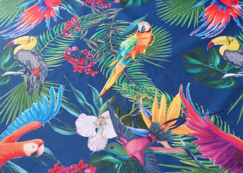 May include: A blue background with a tropical print featuring parrots, toucans, and hummingbirds. The print also includes green leaves, pink flowers, and yellow flowers.