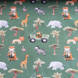 May include: A green fabric with a repeating pattern of safari animals, including a fox, zebra, elephant, giraffe, lion, and a jeep. The animals are illustrated in a cartoon style and are surrounded by palm trees and other foliage.