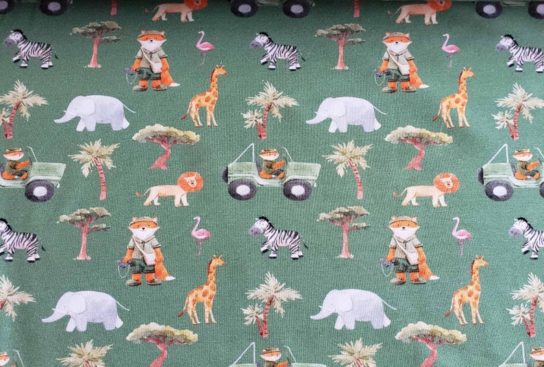 May include: A green fabric with a repeating pattern of safari animals, including a fox, zebra, elephant, giraffe, lion, and a jeep. The animals are illustrated in a cartoon style and are surrounded by palm trees and other foliage.