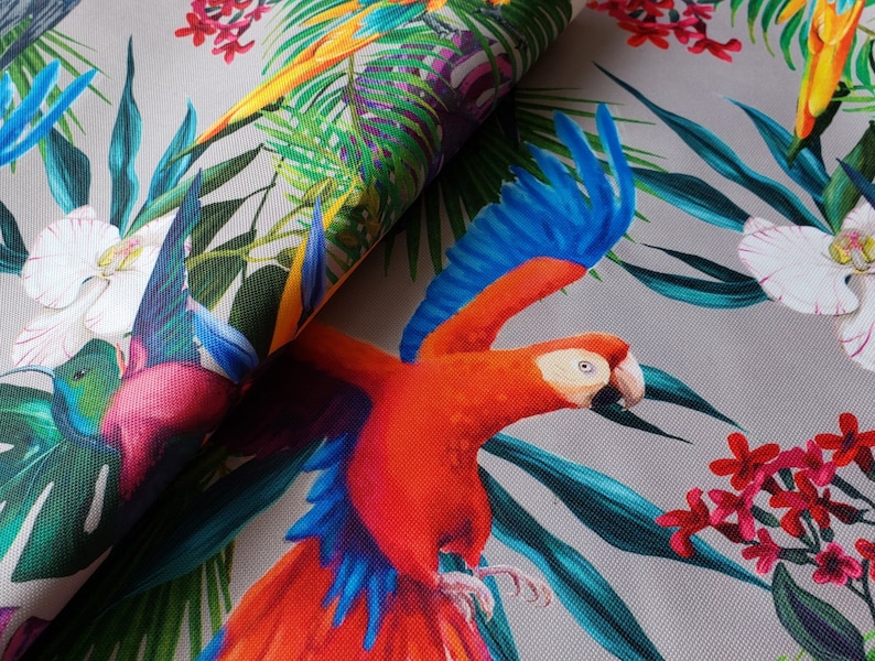May include: A tropical fabric featuring a vibrant red and blue parrot with green and blue leaves, white orchids, and pink flowers.