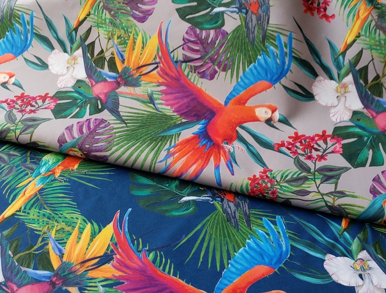 May include: A tropical fabric with a repeating pattern of colorful parrots, palm leaves, and flowers. The fabric is beige with a blue and green pattern on the bottom.