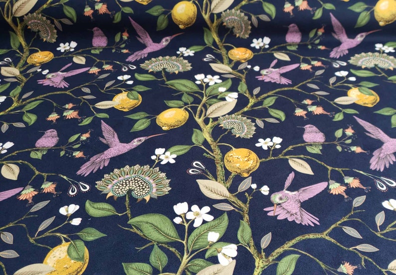 May include: A dark blue fabric with a repeating pattern of hummingbirds, lemons, and flowers. The hummingbirds are pink and have long beaks. The lemons are yellow and have green leaves. The flowers are white and have green stems.