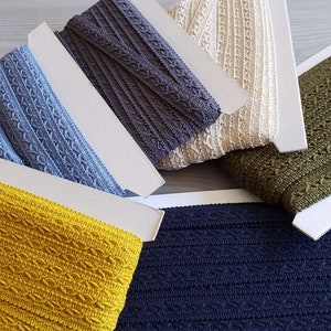 May include: Assortment of six different colors of elastic trim with a textured pattern. The colors are blue, gray, beige, green, yellow, and navy.