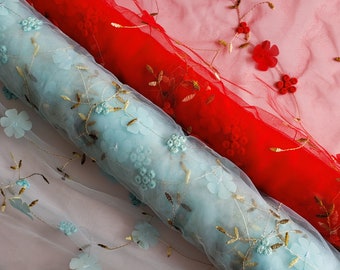 May include: Two rolls of sheer fabric with embroidered floral designs. One roll is light blue with turquoise flowers and the other is red with red flowers.
