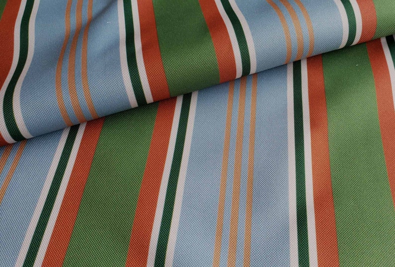May include: Striped fabric in shades of blue, green, orange, and white. The fabric has a woven texture and is perfect for upholstery or crafting projects.