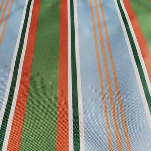 May include: Striped fabric with alternating bands of light blue, white, orange, green, and red.
