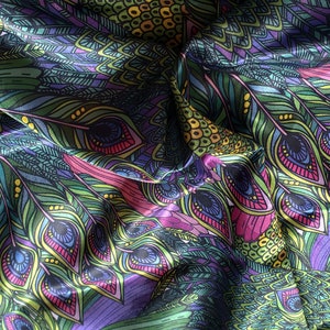 May include: A close-up of a fabric with a peacock feather pattern. The fabric is a mix of green, purple, pink, and yellow colors. The feathers are detailed with intricate designs.