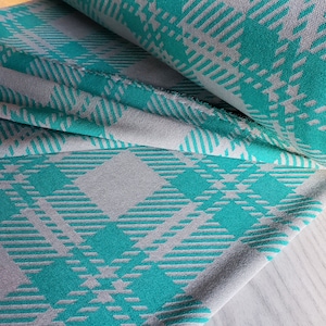 May include: Teal and grey plaid fabric with a soft, textured feel. The fabric is folded in half, showing the pattern on both sides.
