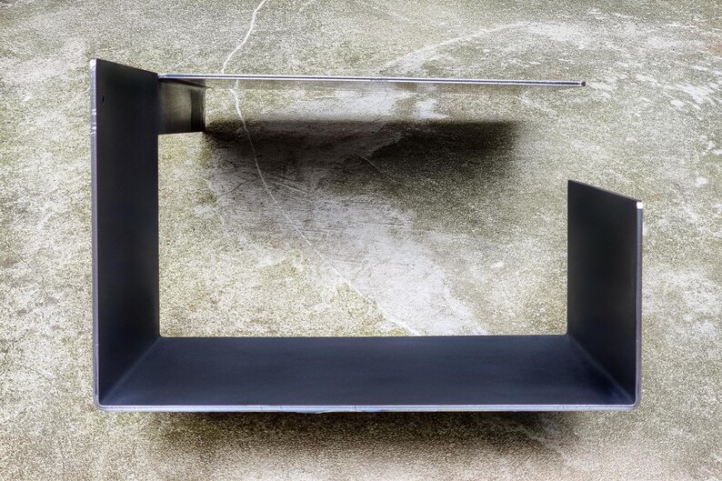 May include: A black metal shelf unit with two shelves. The shelves are rectangular and have a simple, modern design.