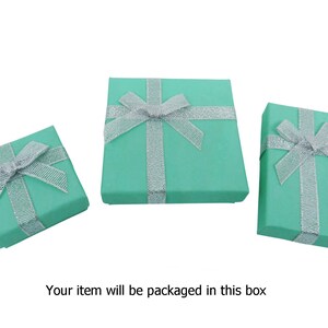 May include: Three turquoise gift boxes with silver ribbon bows. The boxes are different sizes.