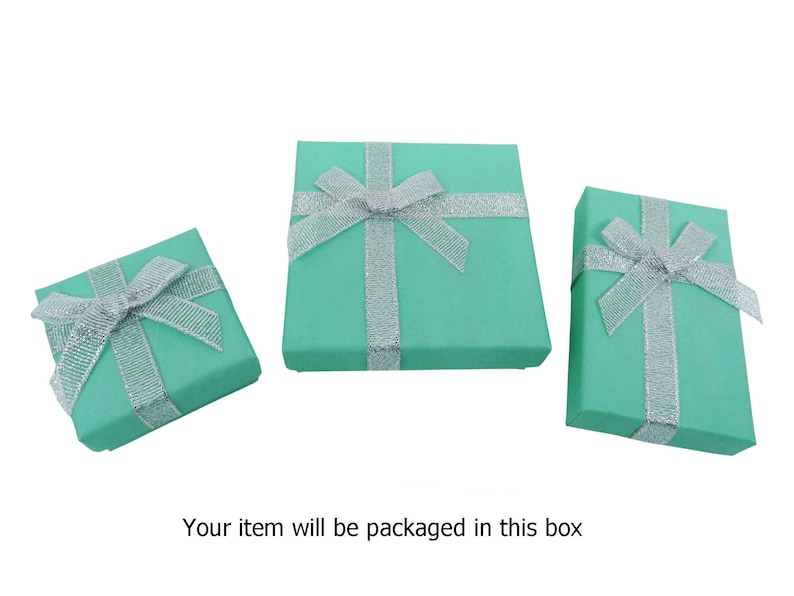 May include: Three turquoise gift boxes with silver ribbon bows. The boxes are different sizes.