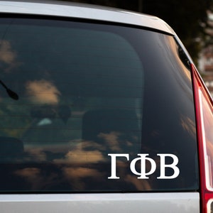 May include: A white vinyl decal with the Greek letters "ΓΦΒ" on a black car window.