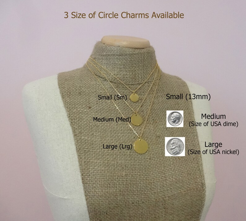May include: Three gold circle charms of different sizes on a mannequin. The sizes are labeled as small (13mm), medium (size of a US dime), and large (size of a US nickel).