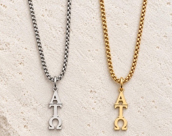 May include: Two necklaces with box chains, one in silver tone and one in gold tone. Each necklace features a vertical pendant displaying the Greek letters Alpha, Tau, and Omega stacked in a column. The pendants match the color of their chains.