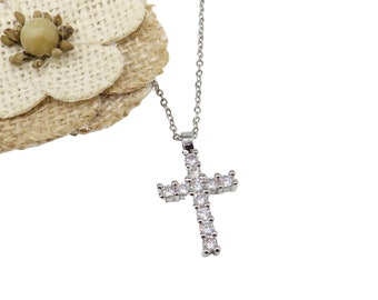 May include: A silver chain necklace with a small, silver cross pendant encrusted with clear cubic zirconia stones.