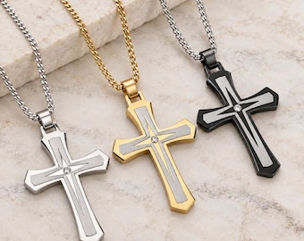 May include: Three cross pendants on matching metal chains. The left is silver-toned, the center is gold-toned, and the right is black. Each cross features a central silver-toned inlay and a small, clear, circular stone set at the intersection.