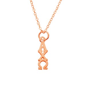 May include: Rose gold necklace with a pendant featuring the Greek letters Alpha, Chi, and Omega in a vertical arrangement. The chain and pendant are a matching rose gold color, creating a cohesive and elegant look.