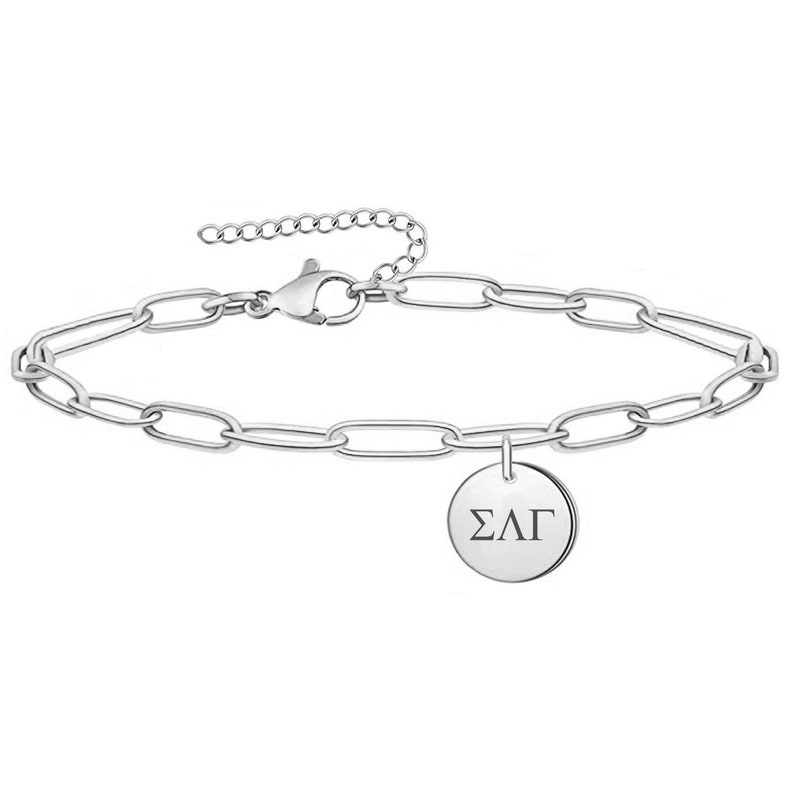 May include: A silver chain bracelet with a round charm that says "&Sigma;&Lambda;&Gamma;".