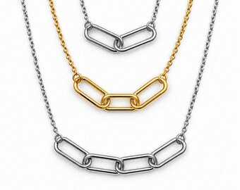 May include: A layered necklace set featuring three distinct chains. The top chain is silver-toned with two links, the middle is gold-toned with three links, and the bottom is silver-toned with four links, all connected to delicate cable chains.