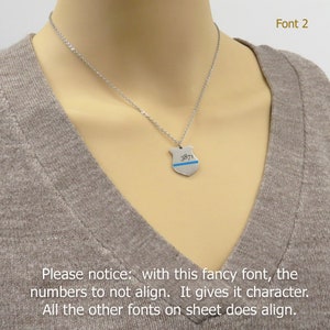 May include: A silver necklace with a silver pendant shaped like a police badge. The badge has a blue line across it and the number "3871" engraved on it. The necklace is on a model wearing a brown shirt. The text "Font 2" is visible in the top right corner of the image. The text "Please notice: with this fancy font, the numbers to not align. It gives it character. All the other fonts on sheet does align." is visible at the bottom of the image.