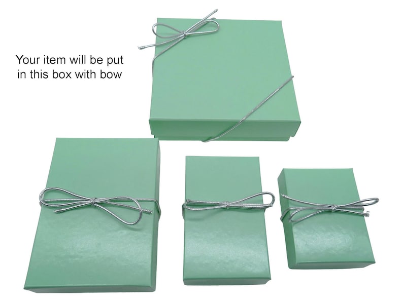 May include: Four mint green gift boxes of varying sizes, each tied with a silver string bow. The largest box is square, while the others are rectangular. Text in the image reads: "Your item will be put in this box with bow."