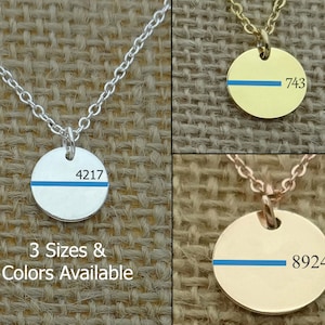 May include: Three silver, gold, and rose gold necklaces with a thin blue line and a number on a round pendant. The text below the necklaces reads "3 Sizes & Colors Available".