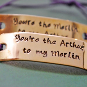 You're The Merlin To My Arthur, You're The Arthur To My Merlin. Hand Stamped Brass ID Tags, Strung on Purple Cord With Sliding Knot Clasp.