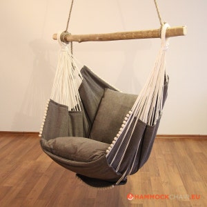 May include: A gray hammock chair with white rope and wooden dowel. The chair has a thick cushion and is hanging from the ceiling.