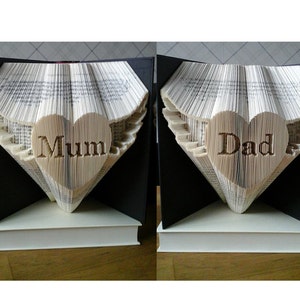 May include: Two book sculptures, each shaped like a heart with wings. The heart on the left says "Mum" and the heart on the right says "Dad".