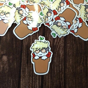 May include: A collection of stickers featuring a cartoon character with blonde hair and a red shirt peeking out of a brown pot. The character has a surprised expression and is surrounded by green leaves.